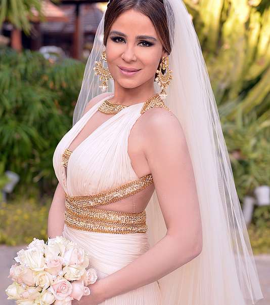 كارول سماحة في فستان أبيض وذهبي يوم زفافها