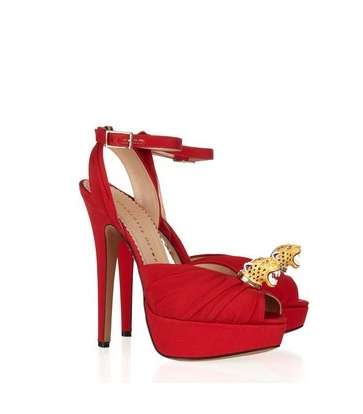 فستان من فيرساتشي وكلاتش من أوسكار دي لا رانتا وحذاء من شارلوت أوليمبيا باللون الأحمر