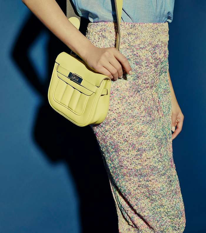 حقيبة بألوان النيون من Hermes وتنورة تويديّة من Chanel